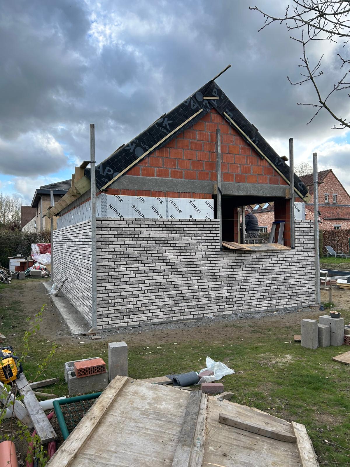 Poolhouse in ruwbouw met witte gevelsteen en houten dakstructuur